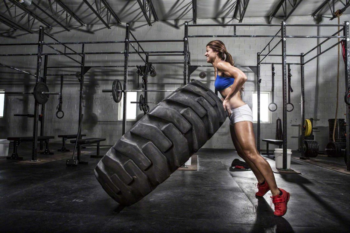 CrossFit athlete flipping a tire --- Image by © Artiga Photo/Corbis